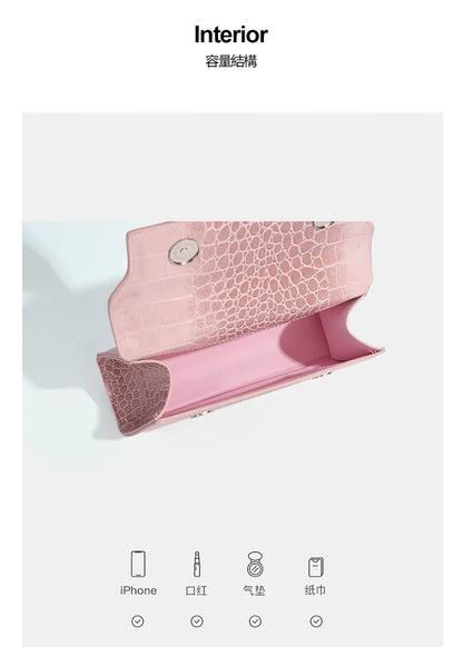 Pink faux leather crossbody clutch with structured crocodile texture and zip closure for carrying everyday essentials.