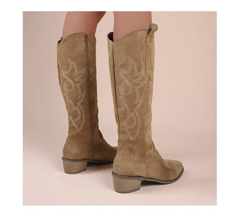 Tan faux-suede tall western boots with white decorative stitching, block heels, and side zippers.