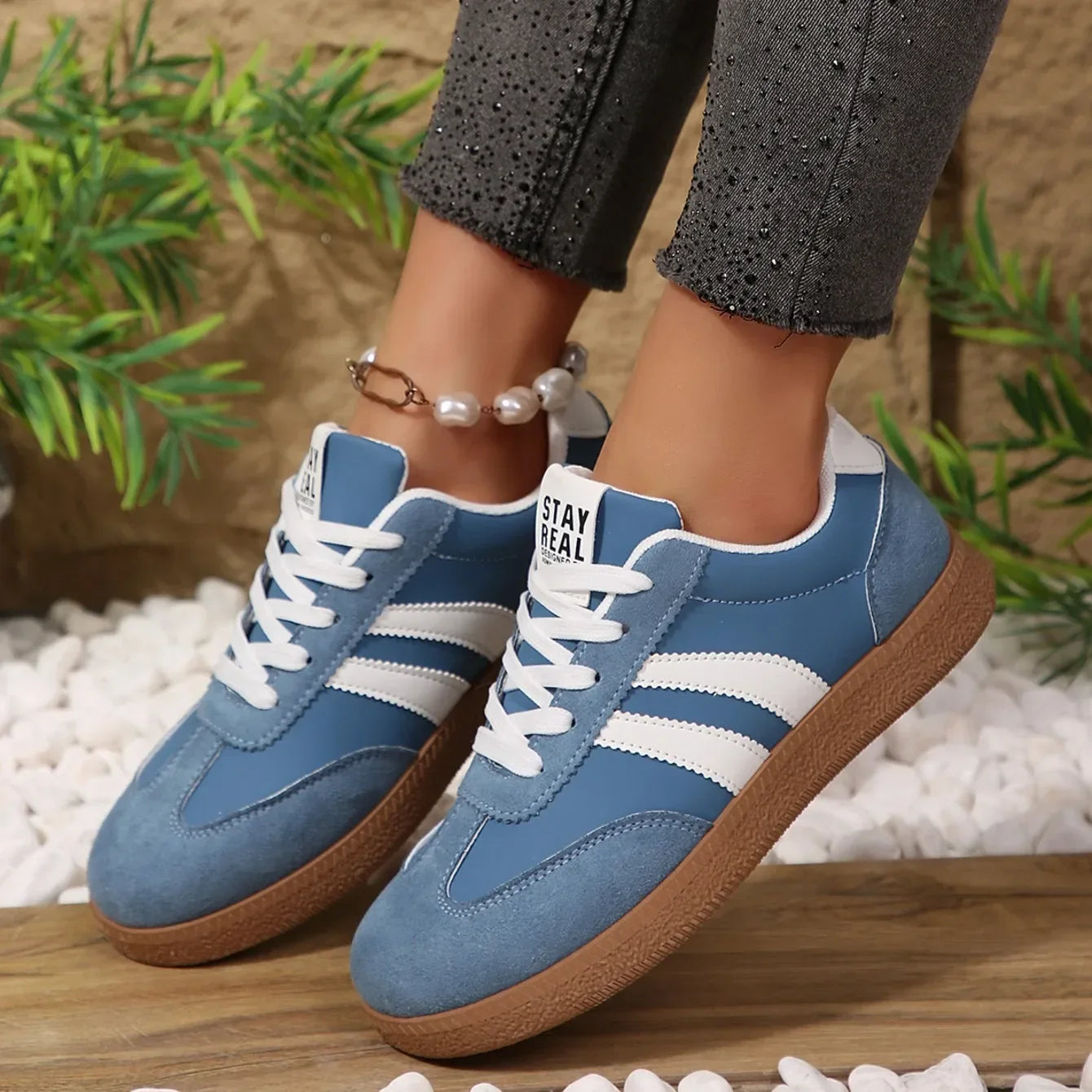 Blue leather and suede slip-on sneakers with white stripes and gum soles for casual daily wear.