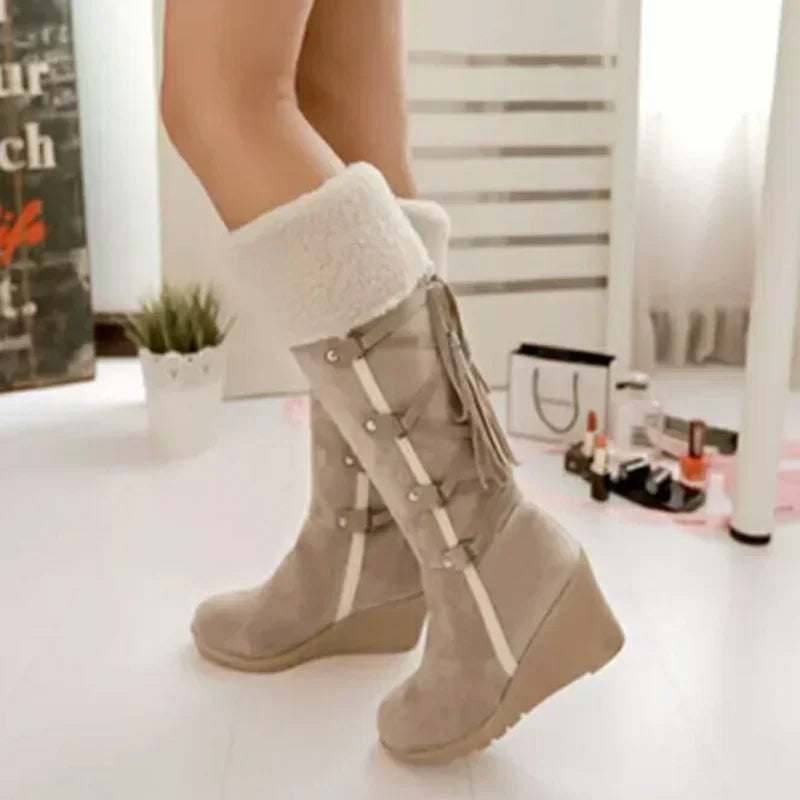 Beige suede knee-high wedge snow boots with white faux-fur cuffs, side tassels, and straps.