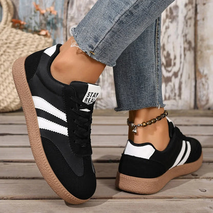 Black and white leather slip-on sneakers with gum soles for casual daily wear.