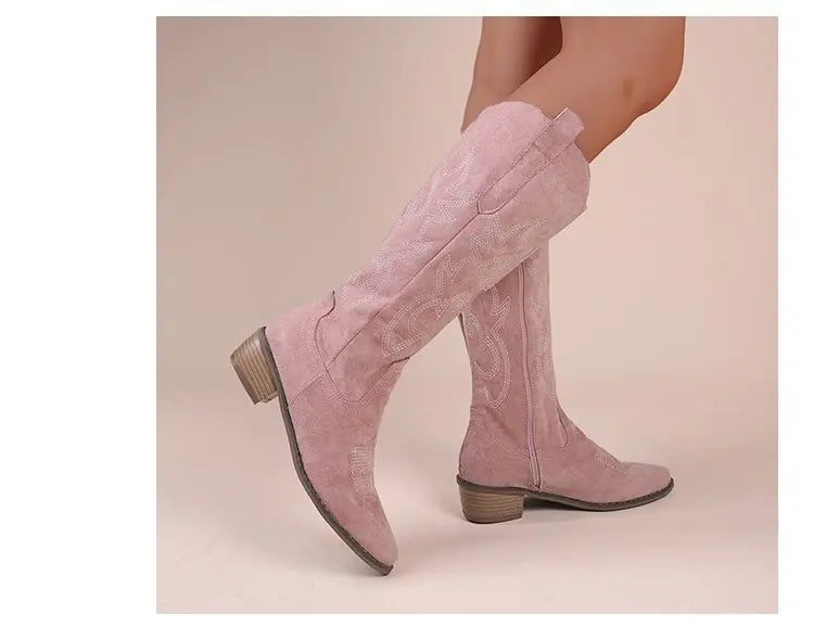Pink suede knee-high Western cowboy boots with chunky heels and white embroidery details.