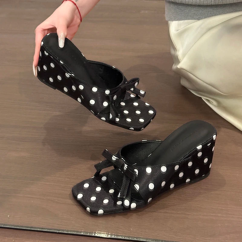 Black and white polka dot wedge sandals with a front bow for casual wear.