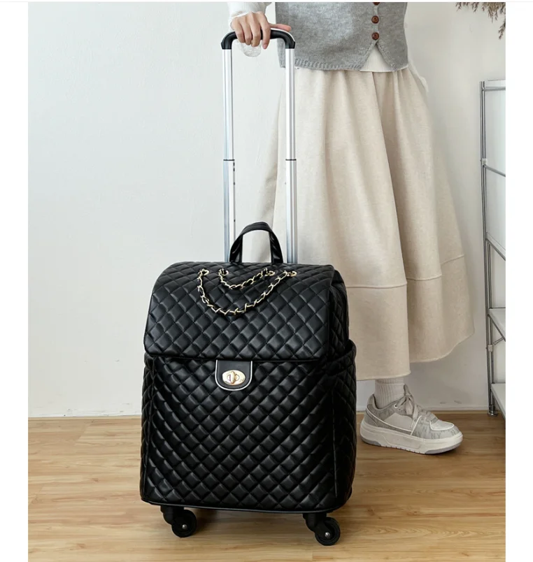 Black quilted faux leather rolling travel bag with a gold chain accent, top handle, and extendable trolley handle.
