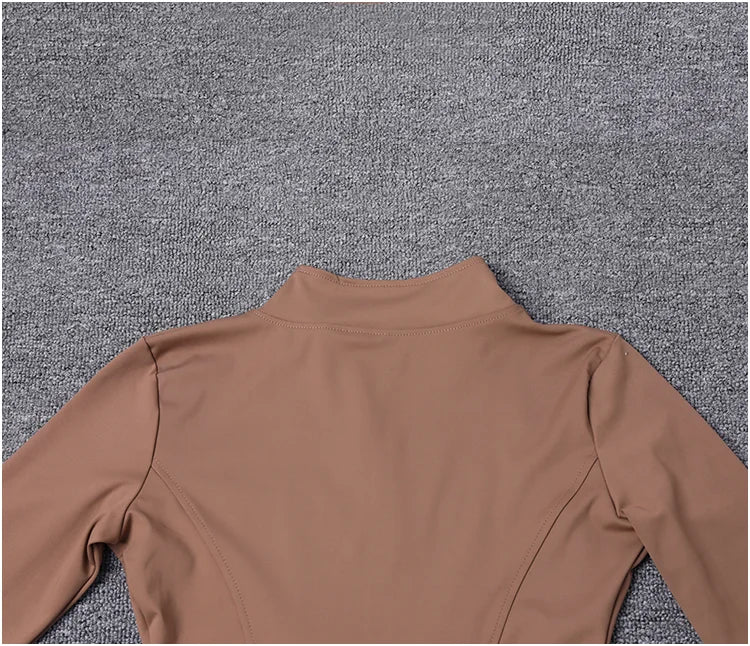 Tan, seamless polyester sport jacket with a high collar and fitted design for gym training and yoga.