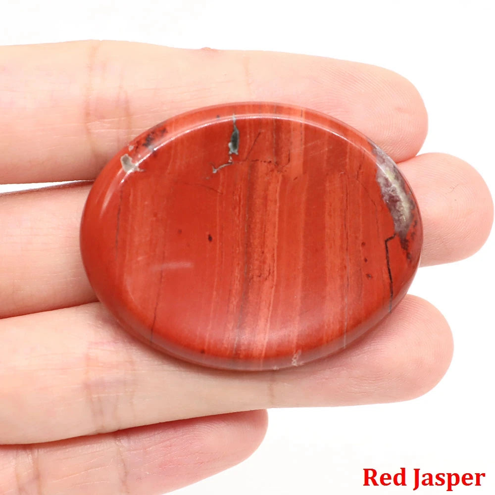 Smooth, oval red jasper palm stone with natural mineral inclusions for home decor meditation.