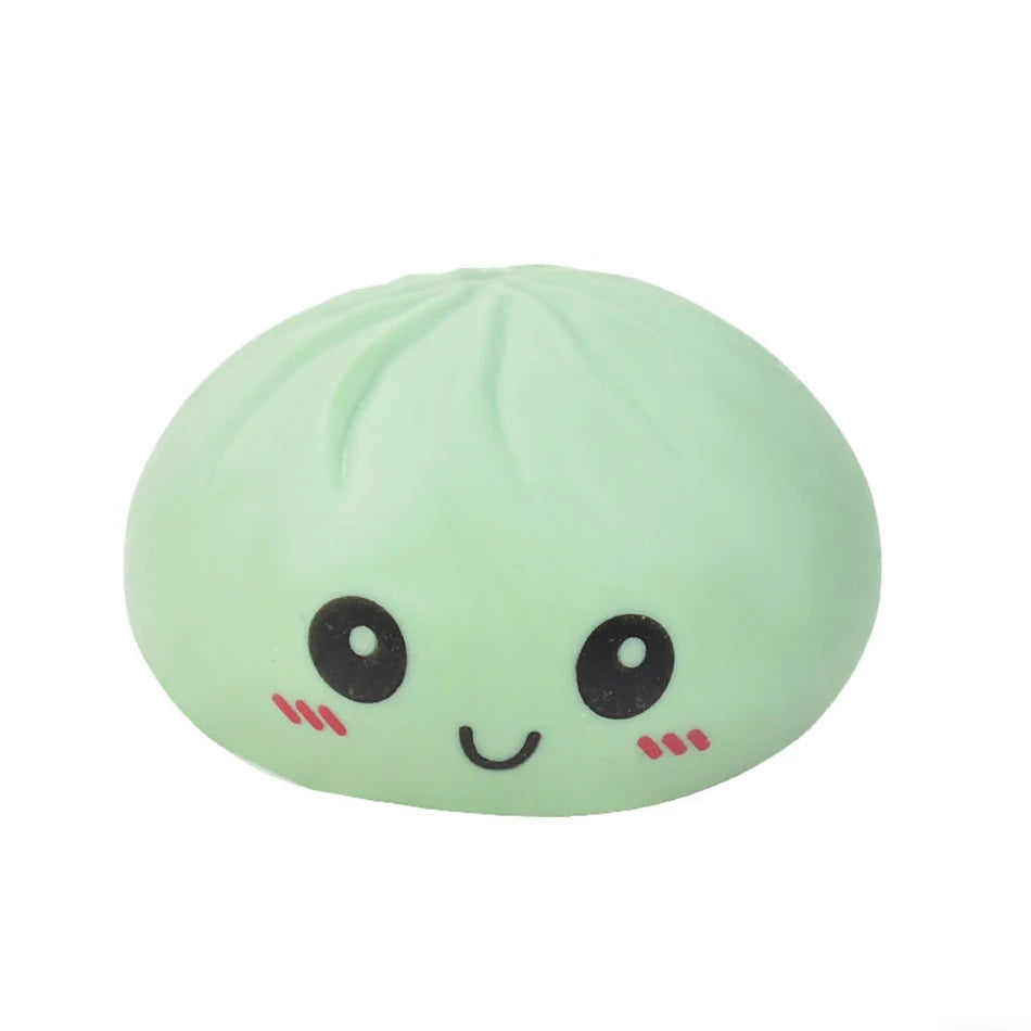 Light green silicone dumpling squishies fidget toy with a cute smiley face for stress relief.