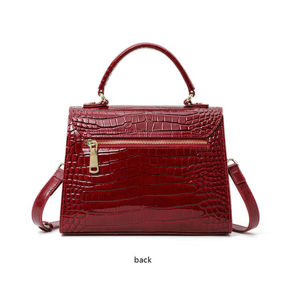 Red lacquer cowhide leather handbag with a crocodile pattern, top handle, and a gold-toned zipper pocket.