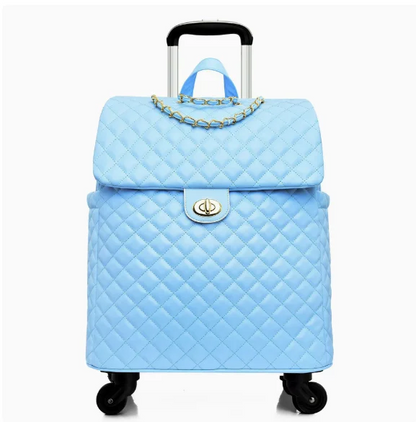 Light blue quilted leather rolling trolley suitcase with gold chain accent, turn-lock closure, and retractable handle.