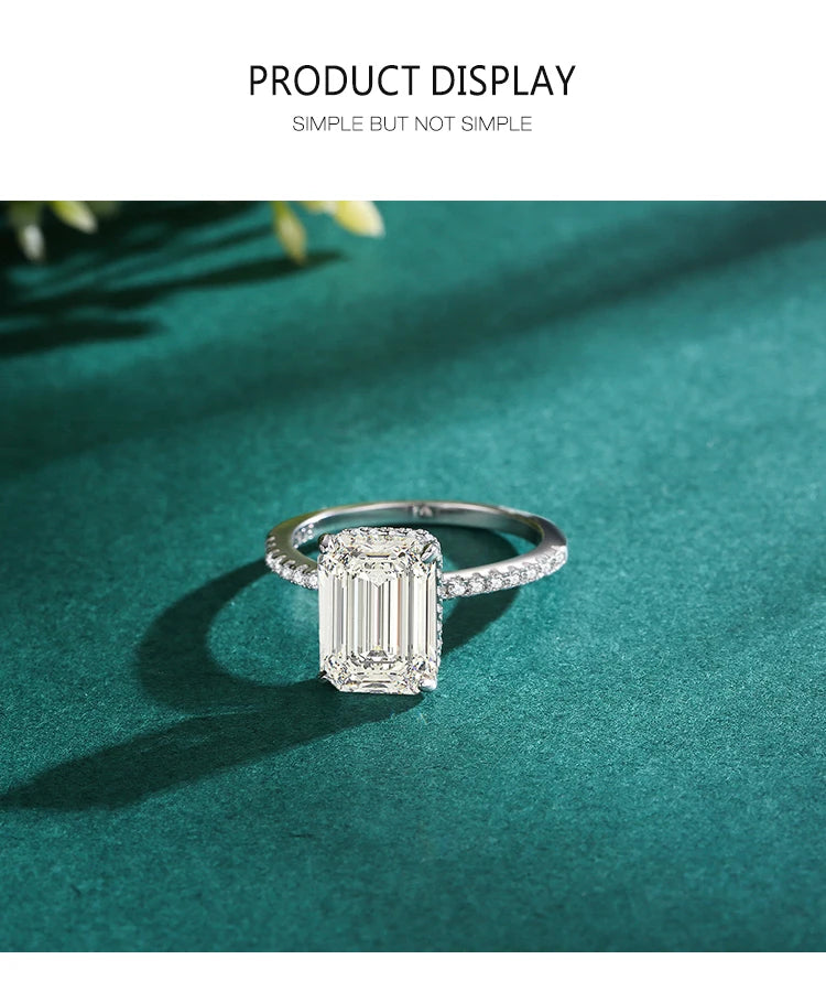 Silver ring with a large rectangular center stone and pavé band on a green surface.