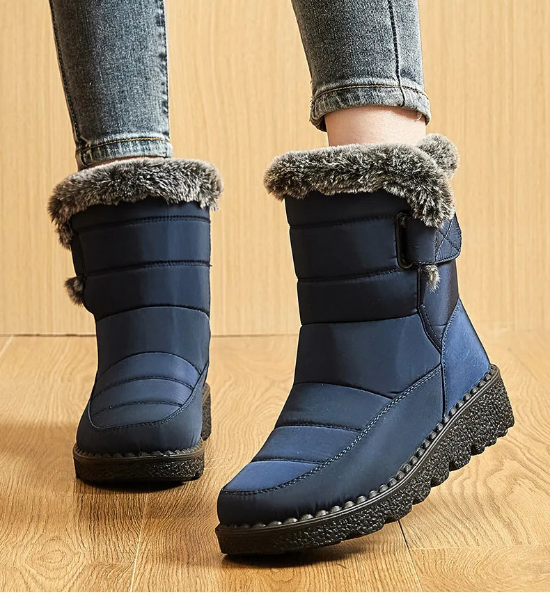Navy blue quilted winter snow boots with fur trim, side straps, and textured black rubber soles.
