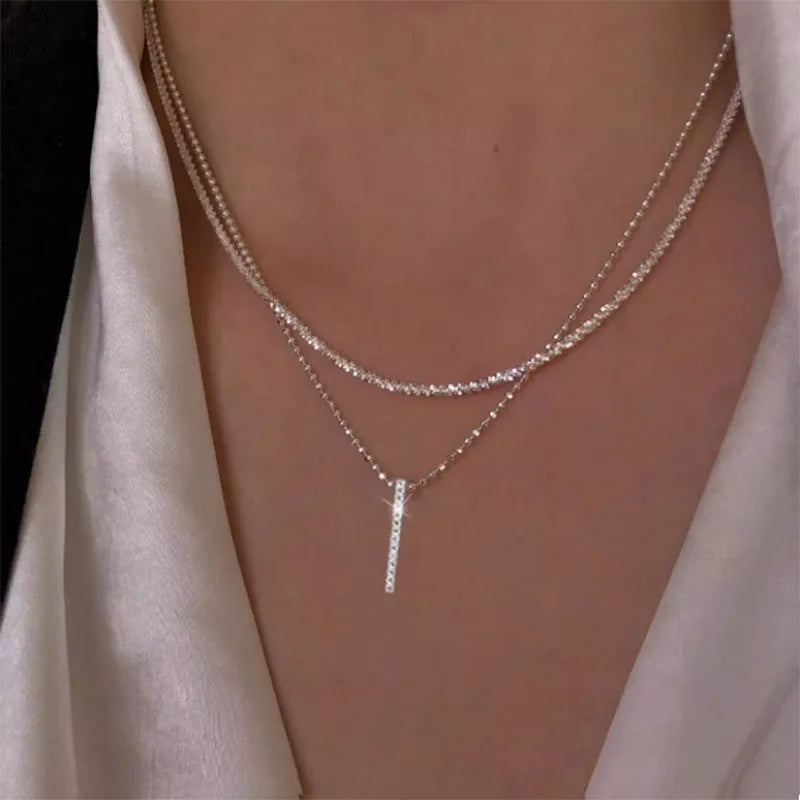 Women's gold-tone layered chain necklace with pendant detail