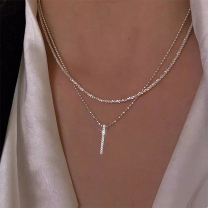 Women's gold-tone layered chain necklace with pendant detail