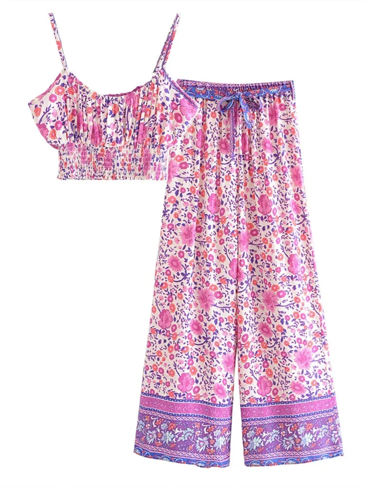 Pink floral print flowy two-piece set with a smocked crop top and high waist drawstring pants for summer vacation.