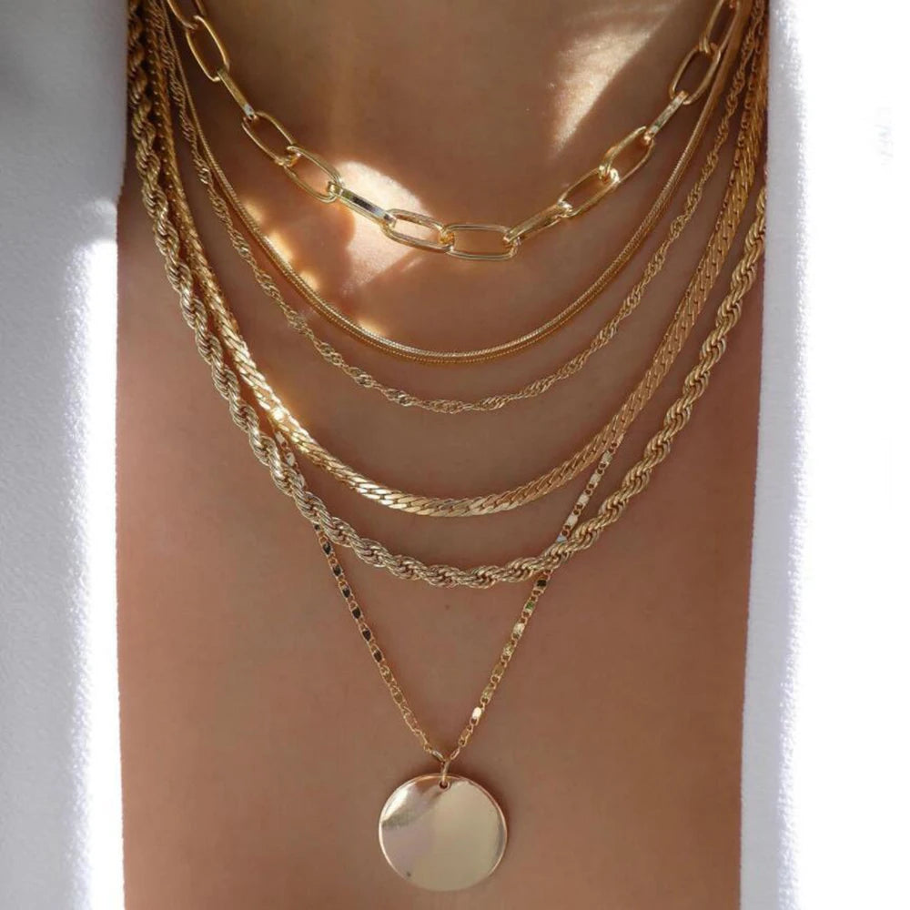 Layered necklace set featuring multi-strand chains and a round pendant