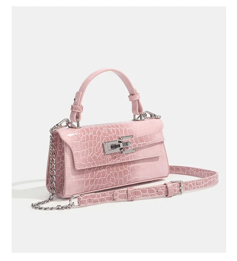 Pink faux leather crossbody bag with croc texture, silver clasp, and adjustable strap for daily errands.