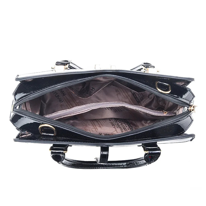 Black patent leather tote handbag with open zipper revealing a patterned lining and zippered center compartment.