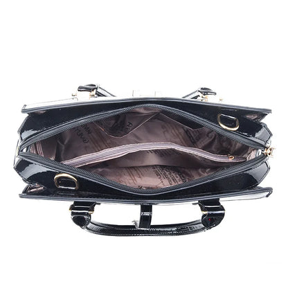 Black patent leather tote handbag with open zipper revealing a patterned lining and zippered center compartment.