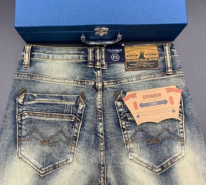 Blue distressed stretchy tapered jeans with back pockets and stitched details for daily comfort.