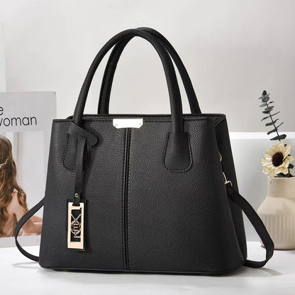 Black structured faux leather tote bag with zip closure and adjustable strap for everyday use.