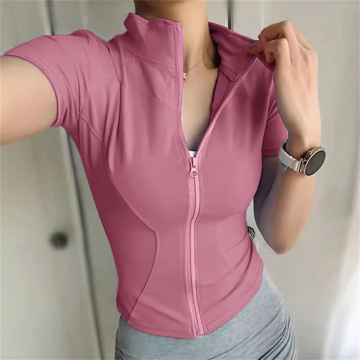 Dusty pink polyester zip-front fitted sports jacket for running, cycling, and yoga.