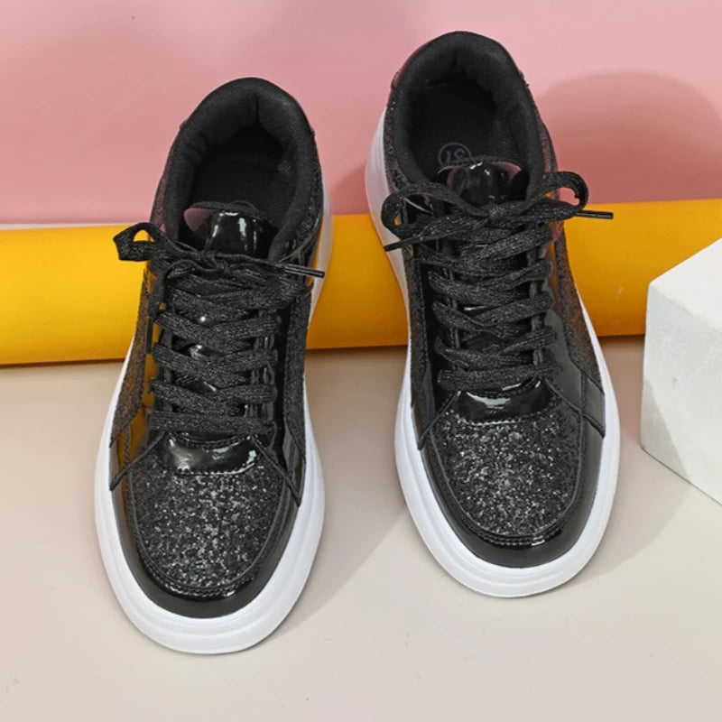 Black lace-up sneakers with sequined toes, patent trim, and thick white soles.