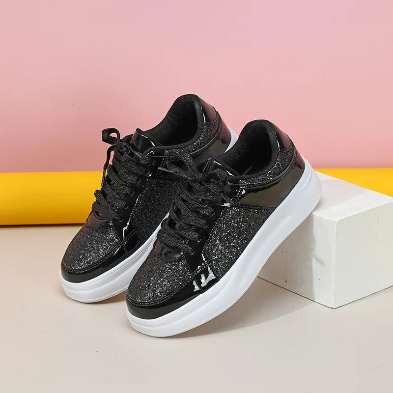 Black sequin lace-up sneakers with chunky white soles and patent leather trim.
