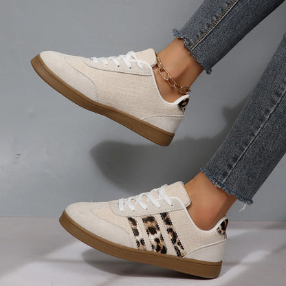 Beige canvas sneakers with leopard print stripes, white laces, and cushioned soles for outdoor walking and comfort.