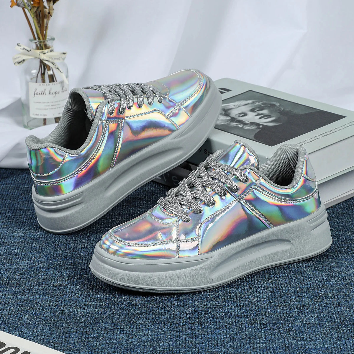 A pair of casual lace-up sneakers with holographic metallic uppers and thick grey platform soles.