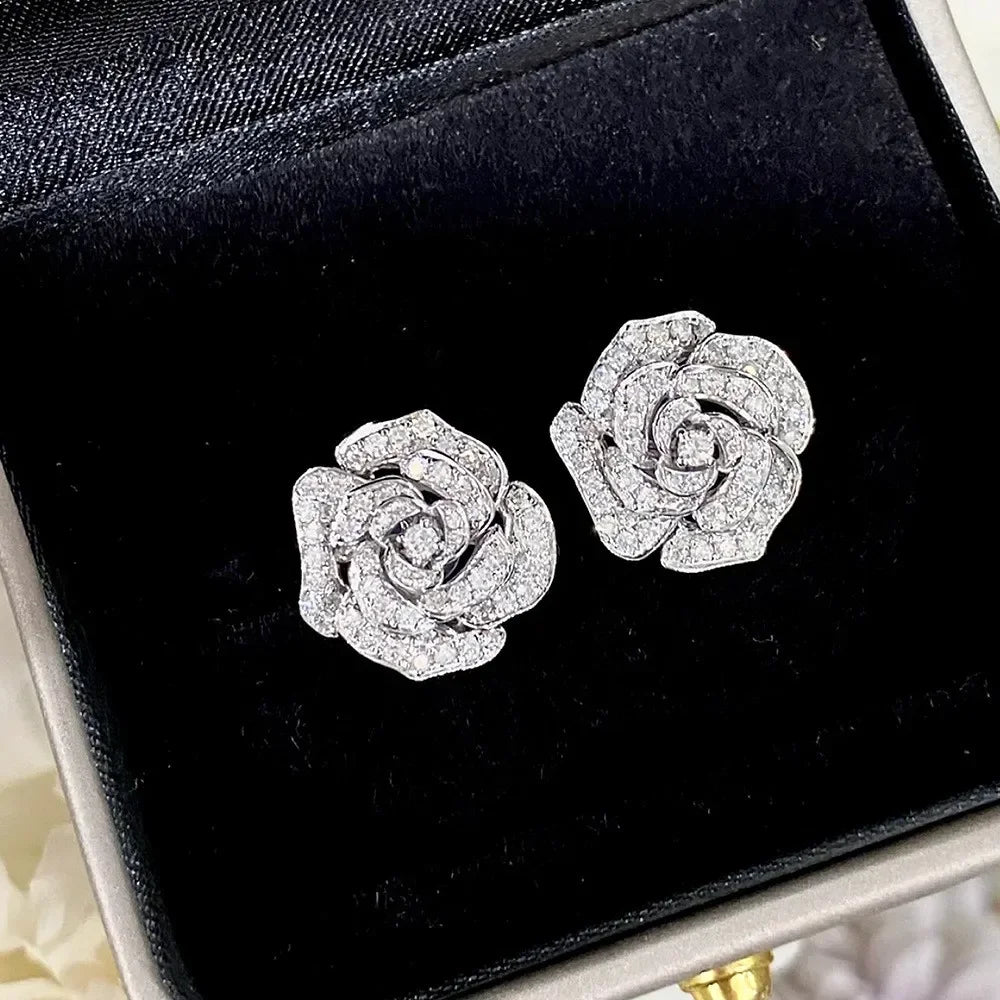 Silver stud earrings in the shape of a blooming rose, pavé-set with clear cubic zirconia stones.