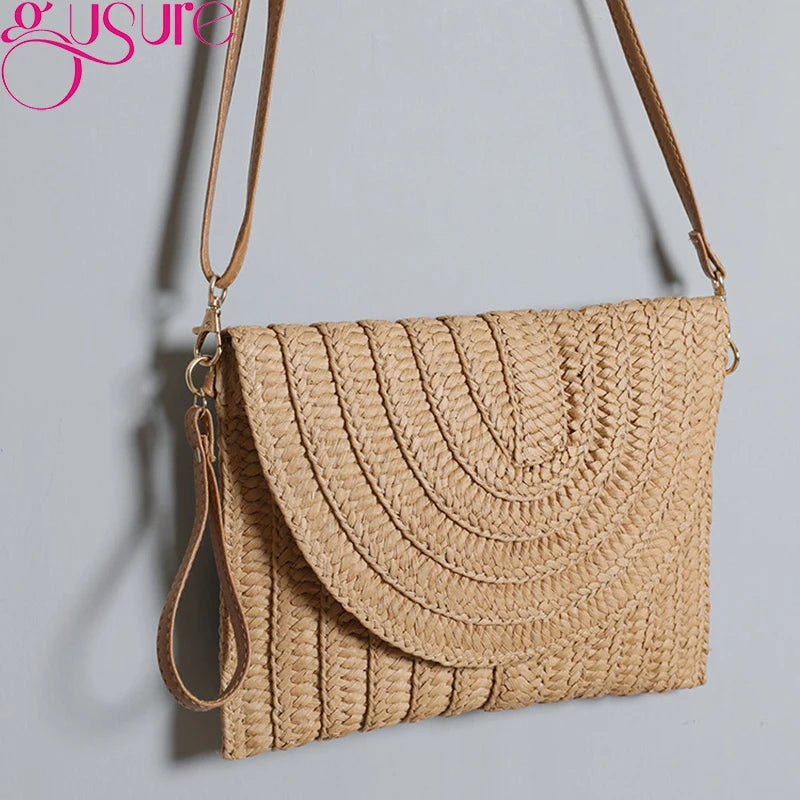 Beige straw woven envelope crossbody bag with an adjustable strap for beach travel.