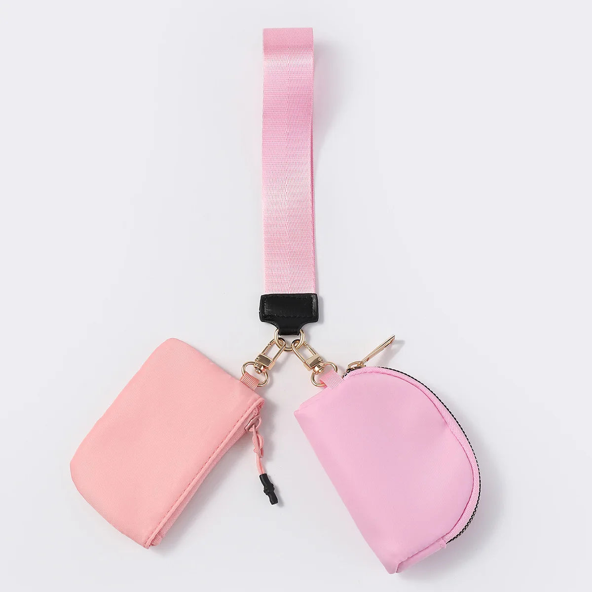Pink nylon dual pouch wristlet wallet with zip closure and adjustable strap for carrying keys and cards.