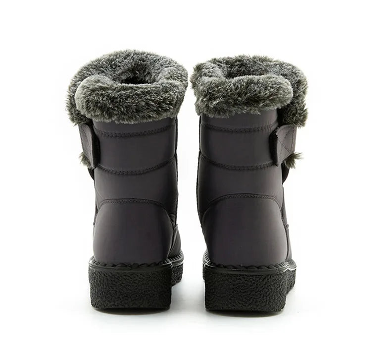 Grey waterproof ankle snow boots with faux fur trim and flat soles viewed from the back.