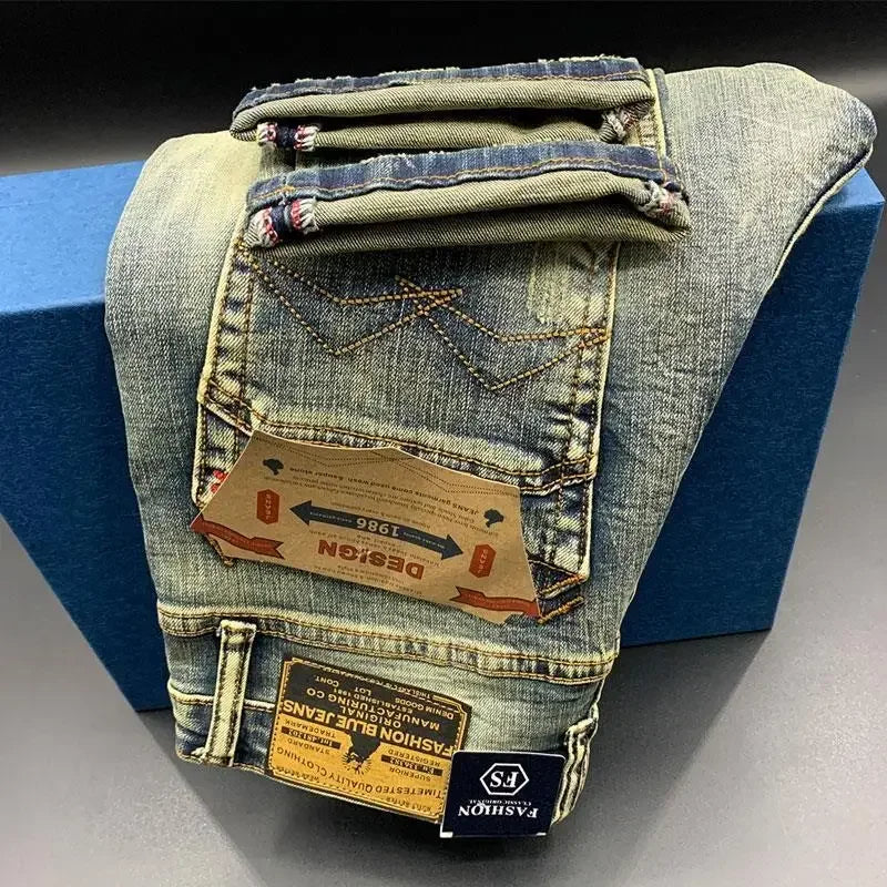 Faded blue midweight denim tapered jeans with stitch detailing and labels, worn for daily comfort.