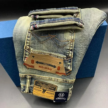 Faded blue midweight denim tapered jeans with stitch detailing and labels, worn for daily comfort.