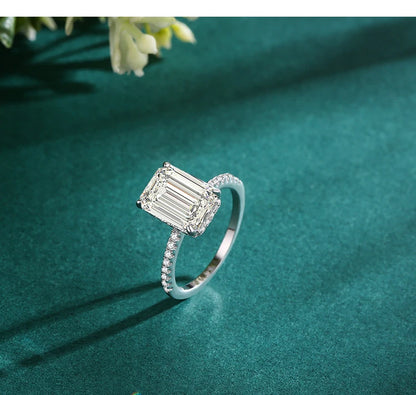 Silver ring with large emerald-cut rectangular center stone and pavé-set zirconia band.