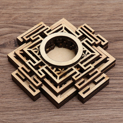 Brown wooden crystal ball holder with geometric laser-cut layered square and circular designs.