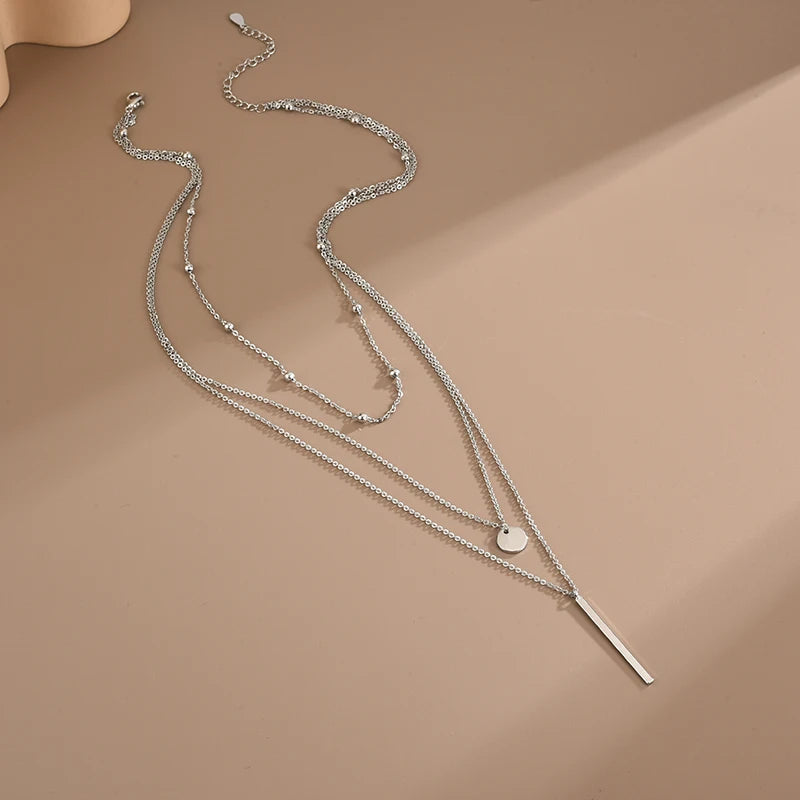 Women's gold-tone layered chain necklace with pendant detail