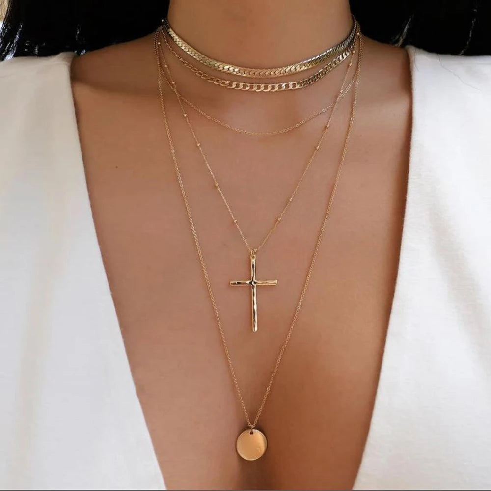 Layered necklace set featuring multi strand chains with cross and round pendants