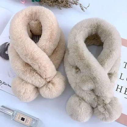 Two soft, plush faux fur cross scarves in beige and light gray, featuring dual pom-pom ends.