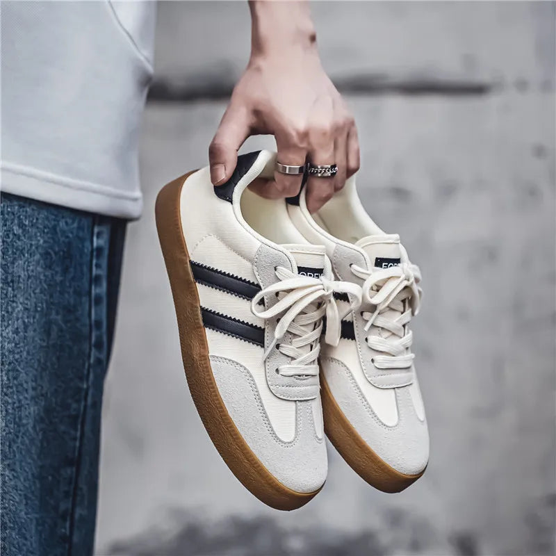 Off-white canvas sneakers with black stripes and brown gum soles, these breathable casual training shoes for daily wear.
