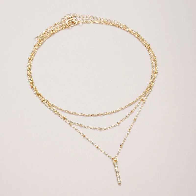 Women's gold-tone layered chain necklace with pendant detail