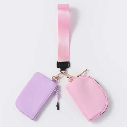 Pink and lavender nylon zip closure wristlet wallet with dual pouches for hands-free carrying of cards and keys.