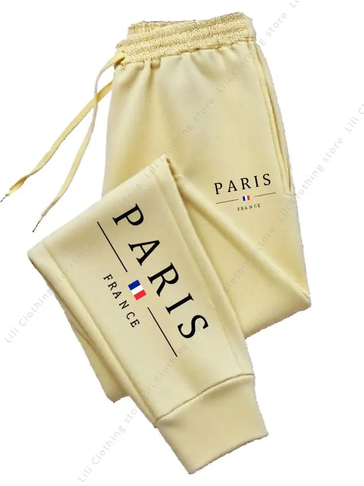 Pale yellow fleece lined high waist jogger pants with Paris France graphic for cozy lounge wear.