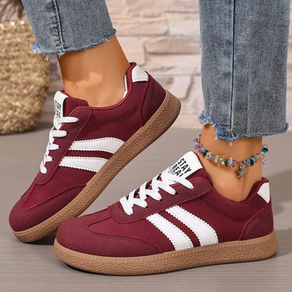 Maroon leather slip-on sneakers with white stripes, white laces, and gum soles for casual daily wear.