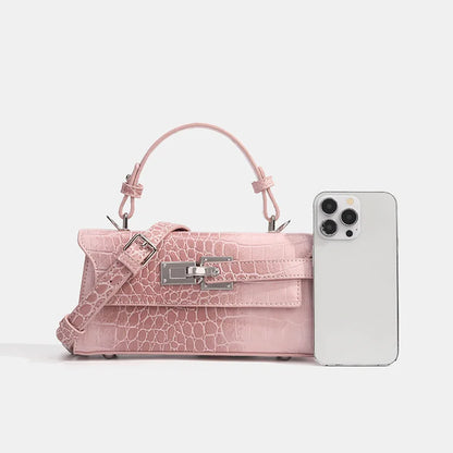 Pink faux leather crossbody with croc texture, silver clasp, and adjustable strap for everyday essentials.