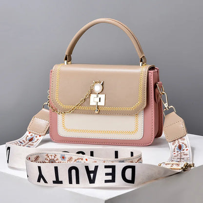 Multicolor faux leather shoulder bag with top handle and patterned fabric crossbody strap with text.