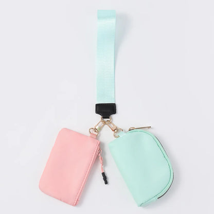 Pink and mint nylon zip closure wristlet wallet with dual pouches for daily errands.