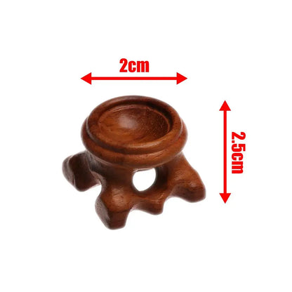 Brown wooden crystal ball stand, 2cm wide and 2.5cm tall, with four carved legs and a round indentation.