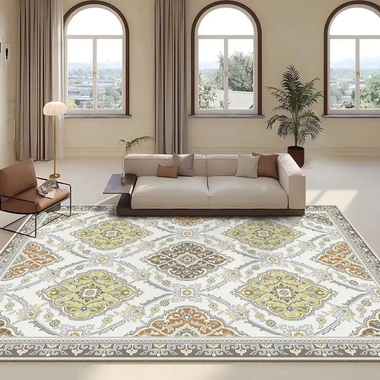 Large area rug with a pale green and tan medallion pattern laid out in a living room.